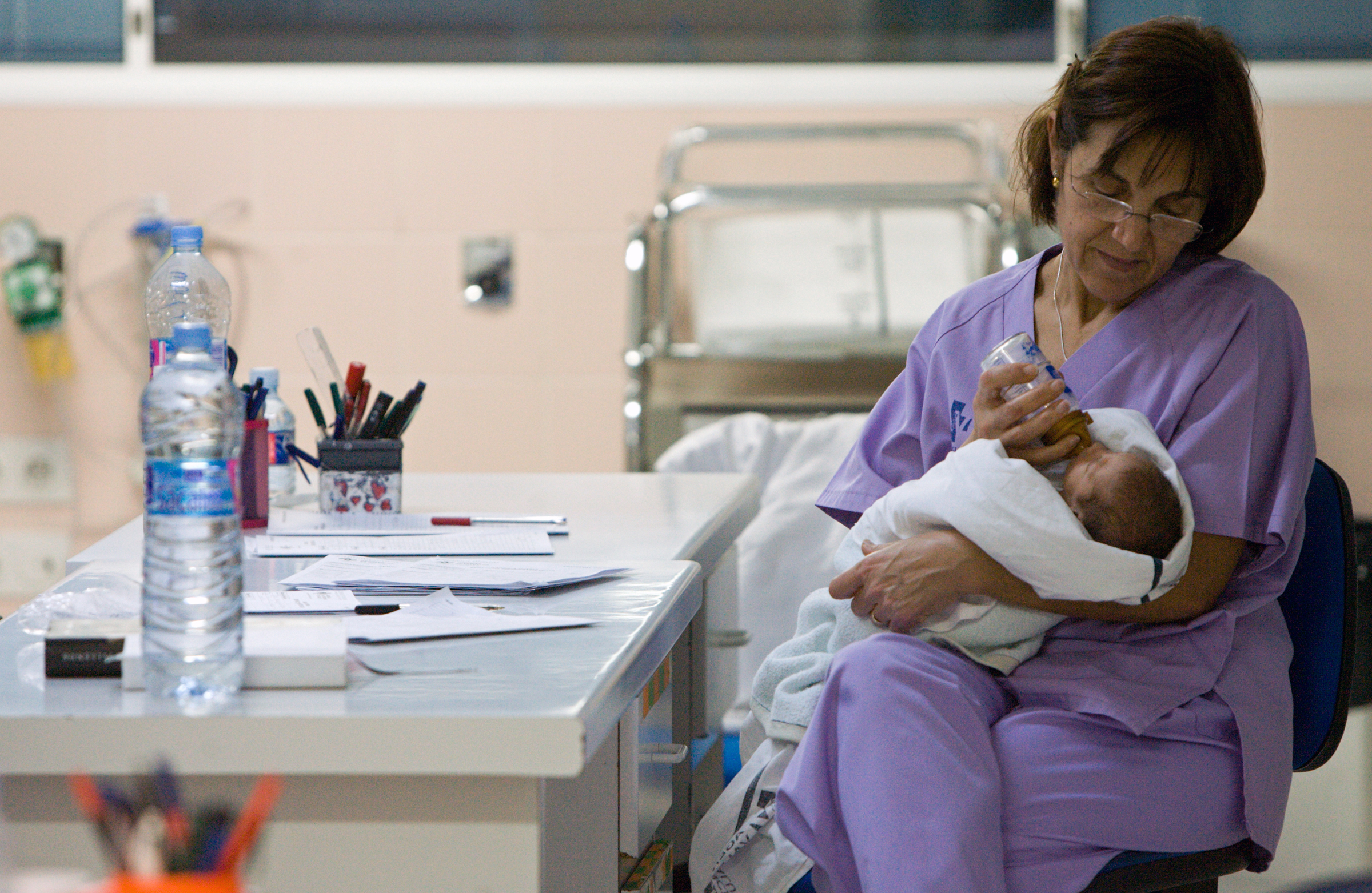 Personal de Enfermería de la Sala de Neonatología alimenta con biberón a un recién nacido