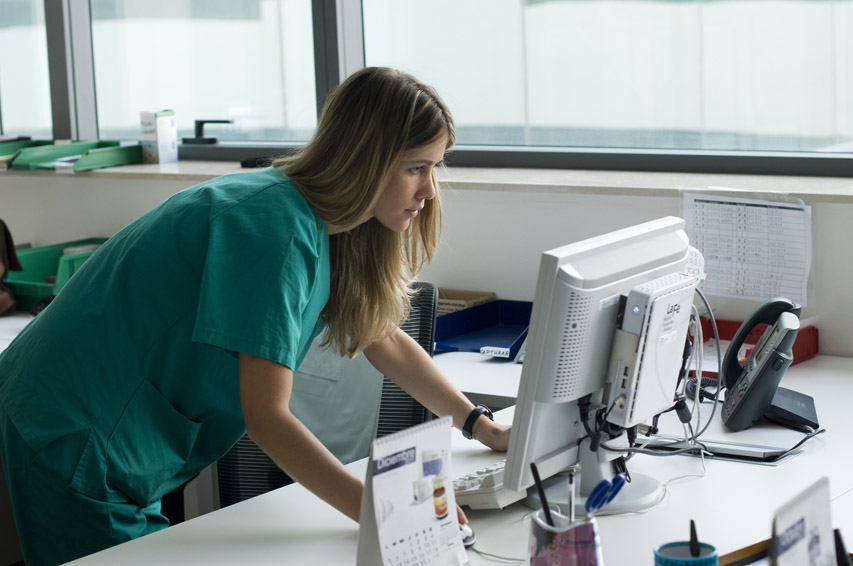 Personal sanitario utlizando ordenadores de trabajo para las historias clínicas